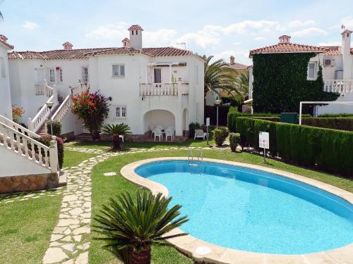 a villa with a swimming pool in front of a house at Apartment Club Sevilla by Interhome in Casas Devesa