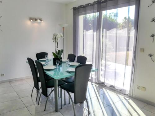 a dining room with a glass table and black chairs at Holiday Home Sainte Marie by Interhome in Tosse