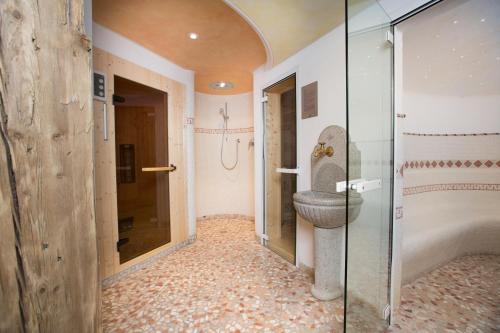 a bathroom with a toilet and a glass shower at Hotel Seppi in Mühlbach