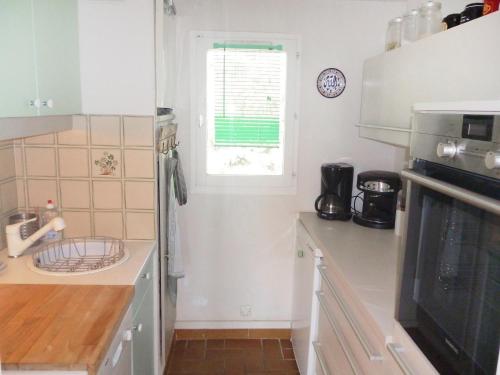 a kitchen with a sink and a window in it at Holiday Home Domaine des Vignes by Interhome in Cogolin