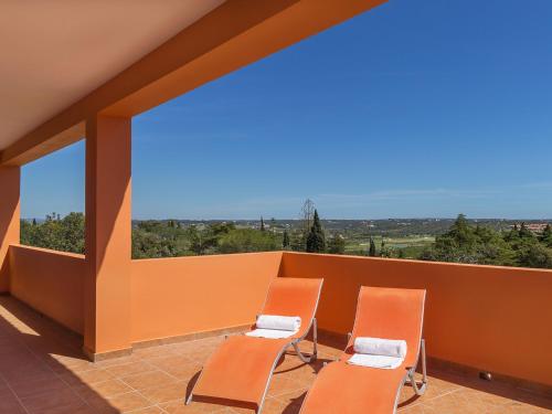 two chairs sitting on a balcony with an orange wall at Villa Casa da Horta by Interhome in Estevais