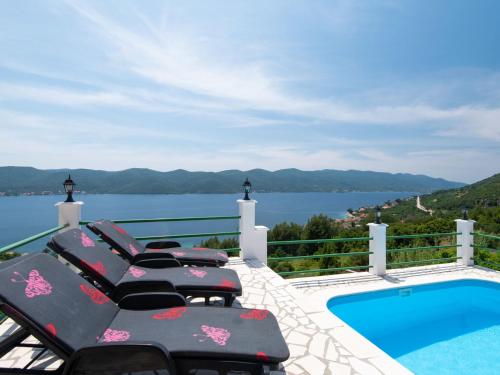 un balcón con sillas y una piscina con vistas. en Villa Anita by Interhome, en Viganj