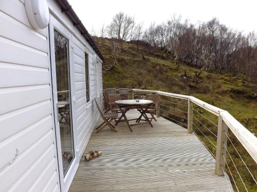 a deck with a table and a picnic table on a house at Chalet MacKinnon by Interhome in Ord