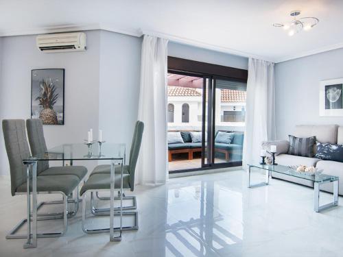 - un salon avec une table et des chaises en verre dans l'établissement Apartment La Maestranza by Interhome, à Marbella