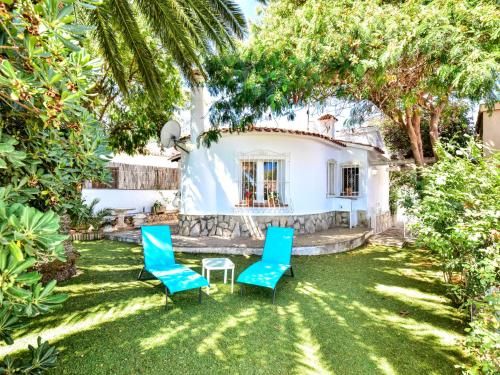 デニアにあるHoliday Home Club San Juan by Interhomeの家の前に椅子2脚とテーブルが置かれた庭