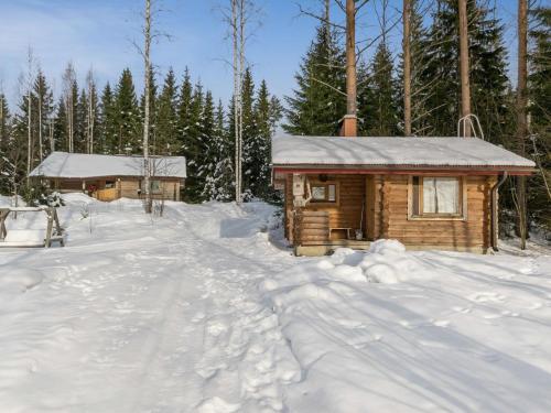 drewniany domek na śniegu z drzewami w obiekcie Holiday Home Hevonkuusi by Interhome w mieście Säkinmäki