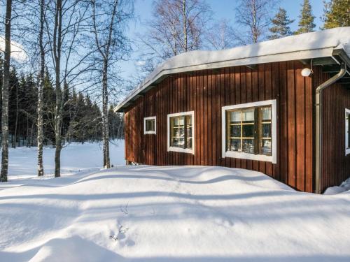 a wooden cabin in the snow with snow at Holiday Home 2235 by Interhome in Savonranta