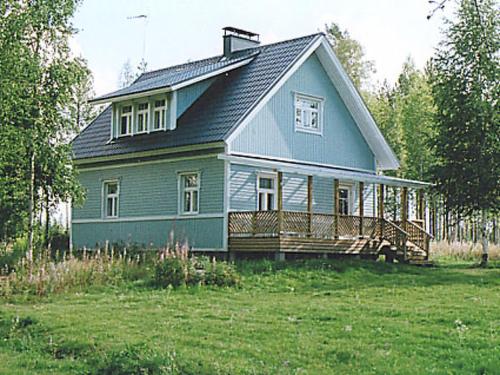 una casa azul con porche y patio en Holiday Home Eteläranta by Interhome, en Armisvesi