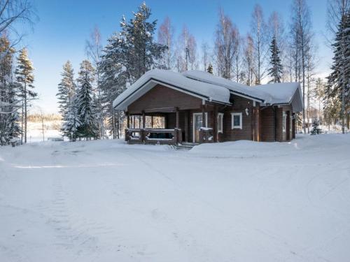 a log cabin with snow on top of it at Holiday Home Villa kontio by Interhome in Savonranta