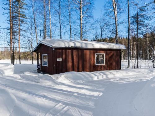 un pequeño cobertizo cubierto de nieve en un bosque en Holiday Home 2234 by Interhome, en Savonranta