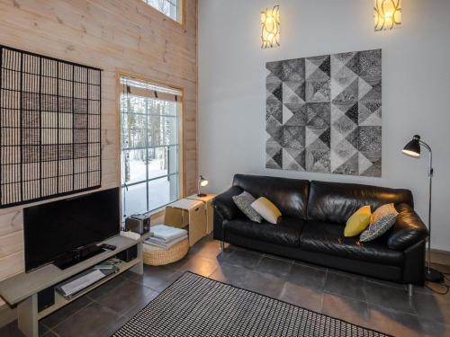 uma sala de estar com um sofá de couro e uma televisão em Holiday Home Koliwood a by Interhome em Kolinkylä