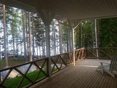 a screened in porch with a chair on a wooden deck at Holiday Home Ylä-hannala by Interhome in Muurame