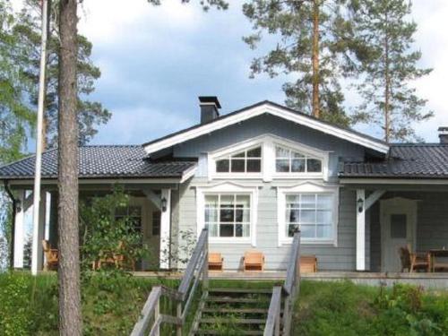 a white house with a staircase in front of it at Holiday Home Varvali by Interhome in Lahdenkylä
