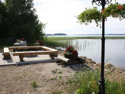 a picnic table next to a body of water at Holiday Home Villa vuorikotka by Interhome in Kaivanto