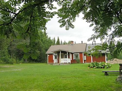 een rood huis met een bank in een tuin bij Holiday Home Välitalo by Interhome in Inkee