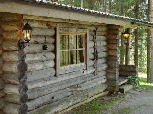 uma cabana de madeira com uma janela e luzes sobre ela em Holiday Home Rinnekämppä by Interhome em Pätiälä