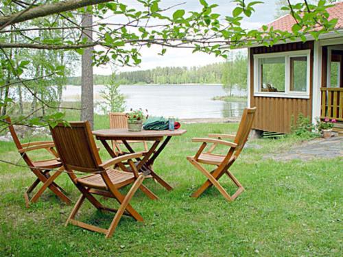 PätiäläにあるHoliday Home Monaco by Interhomeの湖畔の芝生の上に椅子2脚とテーブル