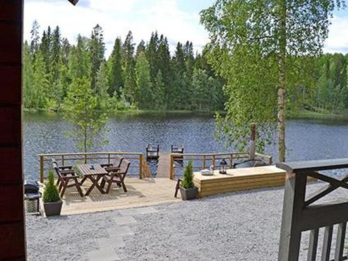 un patio con tavolo e sedie accanto a un lago di Holiday Home Rantamaja by Interhome a Kittilä