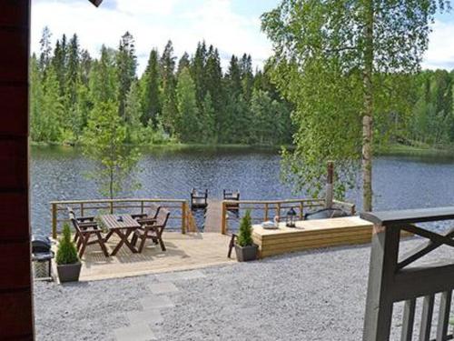 a patio with a table and chairs next to a lake at Holiday Home Rantamaja by Interhome in Kittilä