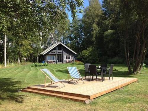 a deck with chairs and a table in front of a cabin at Holiday Home Kivilahti by Interhome in Iltasmäki