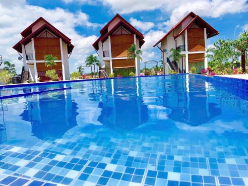 a resort swimming pool with two huts in the background at Avonil Resort Yala in Tissamaharama