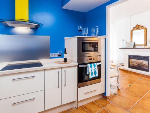 a kitchen with blue walls and white cabinets at Villa Zurbarán by Interhome in Rincón de la Victoria