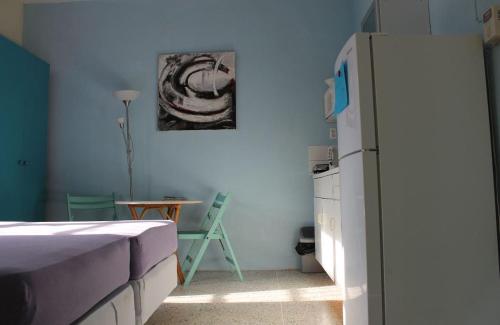 a kitchen with a refrigerator and a table in a room at Caribbean Flower Apartments in Willemstad