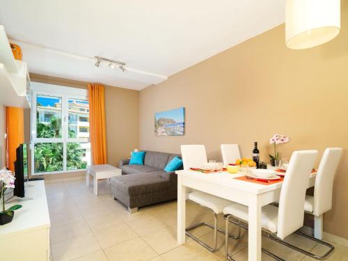 Una sala de estar con una mesa y sillas blancas. en Apartment Sueno del Mar by Interhome, en Moraira