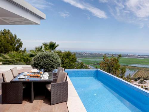 una mesa de comedor y sillas junto a una piscina en Holiday Home Calatrava by Interhome, en Monte Pego