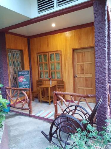 a porch of a house with a table and chairs at TAGBALAYON Lodging House in Siquijor