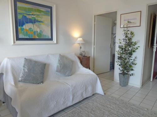 un salon avec un canapé blanc avec deux oreillers dans l'établissement Apartment l'Amiral by Interhome, à Trouville-sur-Mer