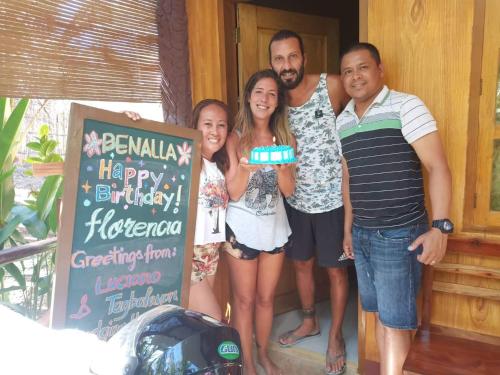 a group of people posing for a picture with a cake at TAGBALAYON Lodging House in Siquijor