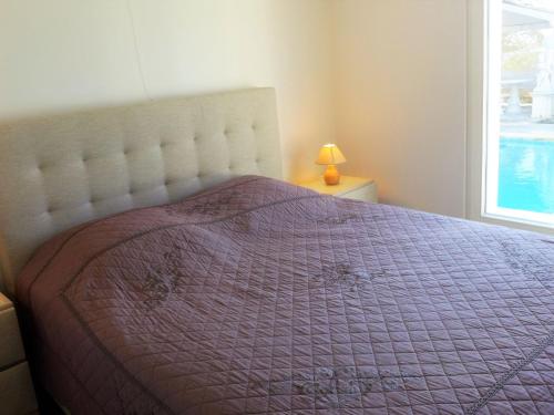 - une chambre avec un lit doté d'une couette violette et d'une fenêtre dans l'établissement Villa Belle Vue by Interhome, à Cavalaire-sur-Mer