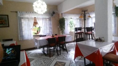 a dining room with tables and chairs and a chandelier at Pousada Bem Querer in Penedo