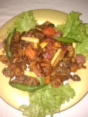 a plate of food with meat and vegetables at VILLA ARIANNA in Wattala