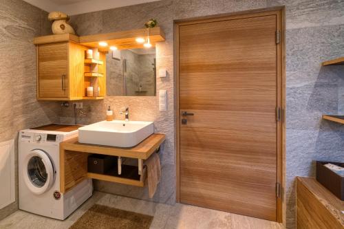 a bathroom with a sink and a washing machine at Chalet Schwarzenstein in Campo Tures