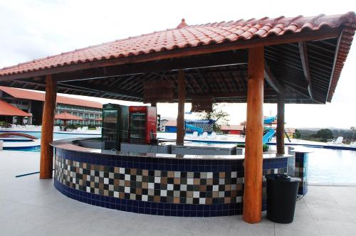 a pavilion with a drink fountain in front of a pool at Hotel Canarius de Gravatá in Gravatá