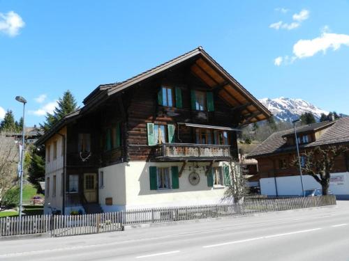 a wooden house with a balcony on the side of a street at Apartment Margrit by Interhome in Gstaad