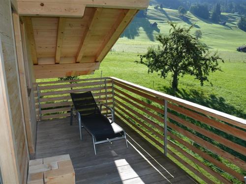 two chairs sitting on the deck of a house at Apartment Alpha by Interhome in Zweisimmen