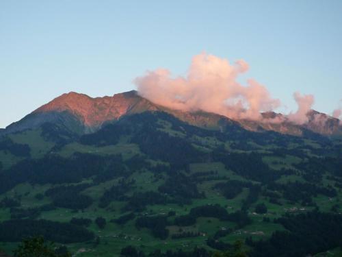a mountain with smoke on top of it at Apartment Ferienhaus Niesen View by Interhome in Erlenbach im Simmental