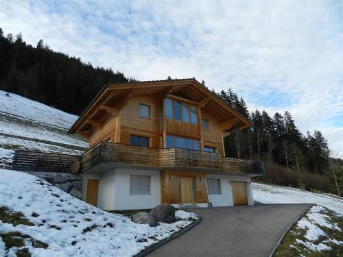 een huis op een heuvel met sneeuw op de grond bij Apartment Gletscherblick- Chalet by Interhome in Zweisimmen