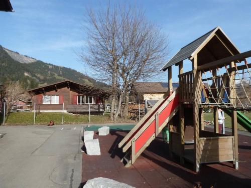 a playground with a slide in front of a house at Apartment Bodehus by Interhome in Adelboden