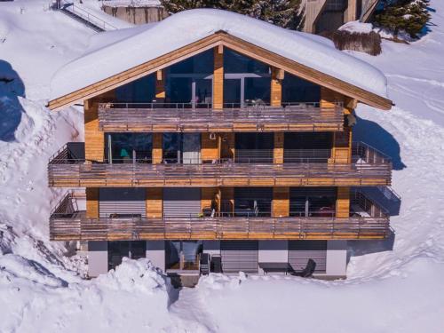 een gebouw in de sneeuw met sneeuw op de grond bij Apartment Apartmenthaus Riederhoru A 1- OG Ost by Interhome in Riederalp