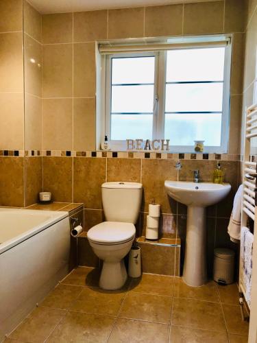 a bathroom with a toilet and a sink and a window at Chestnut Cottage, Shanklin Rural Retreat in Shanklin