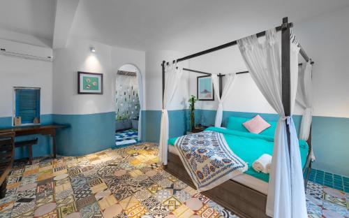 a blue bedroom with a bed and a desk at AnnaBo Nam Hoi An Beach House in Hoi An