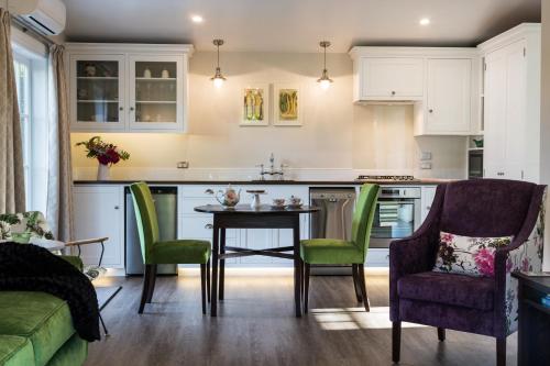 eine Küche mit Tisch und Stühlen in einem Zimmer in der Unterkunft Laurella Cottage in Blenheim