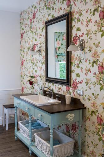 a bathroom with a blue sink and a mirror at Laurella Cottage in Blenheim