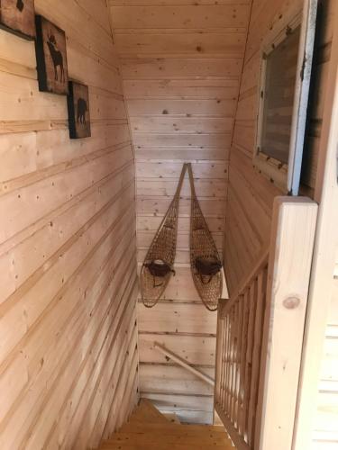 una habitación en una cabaña de madera con dos cestas colgantes en Walden Cabin en Steninge