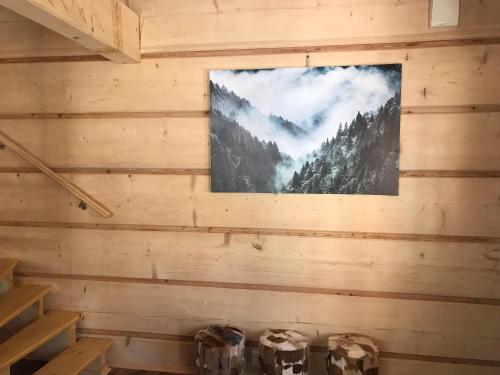 uma parede numa cabana de madeira com uma imagem de uma floresta em Swiss Chalet em Steninge