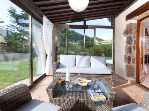 eine Terrasse mit einem weißen Sofa und einem Glastisch in der Unterkunft Holiday Home Origami by Interhome in Calonge